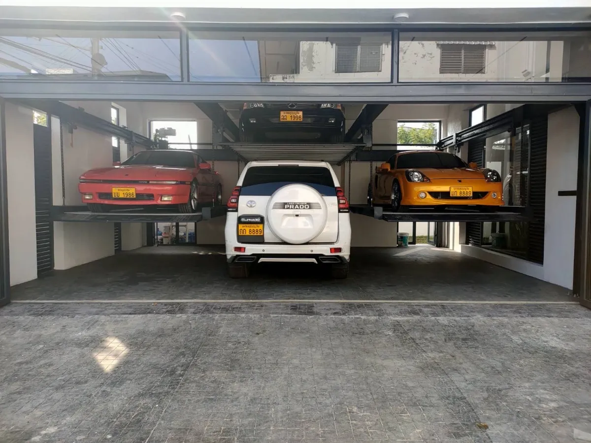 รถ SUV สีขาวจอดใต้แท่นตรงกลางของลิฟท์จอดรถ 6 คัน