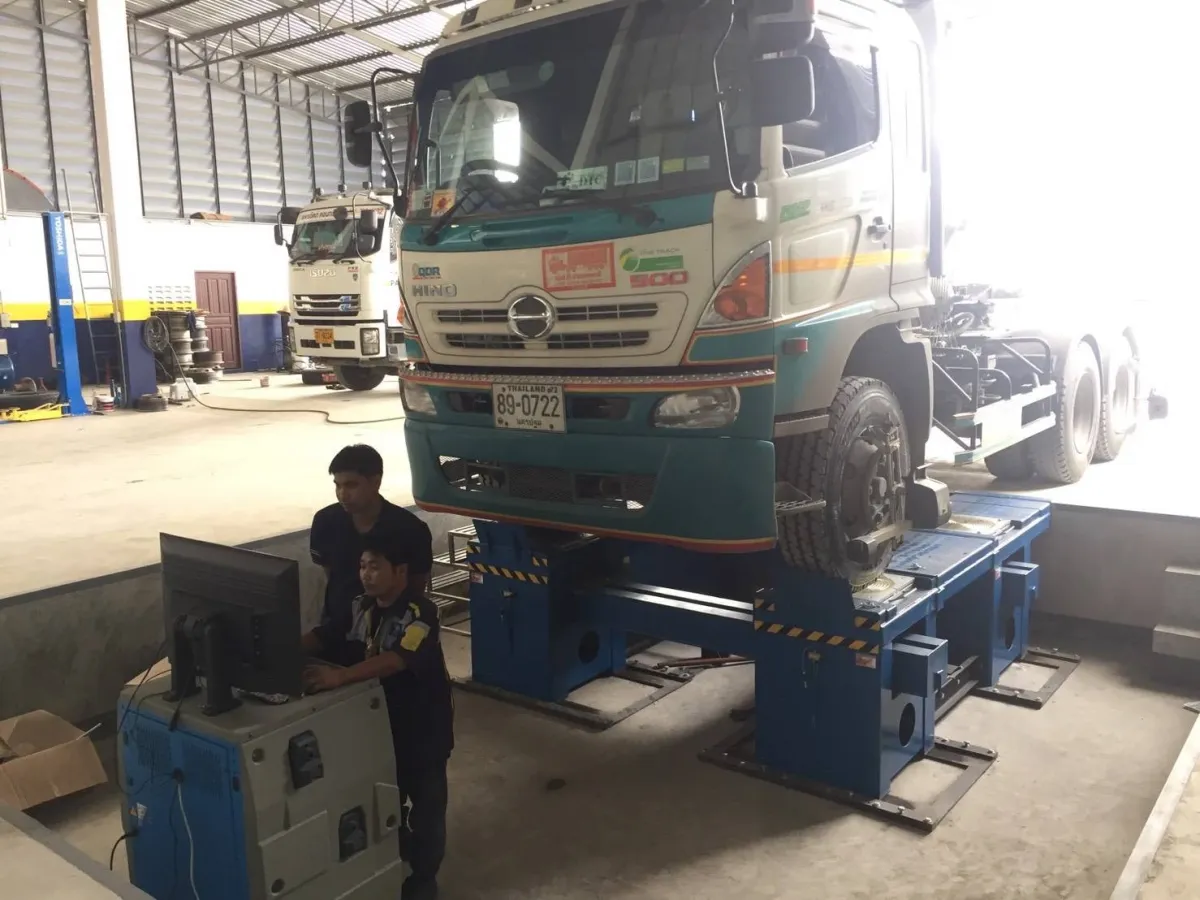 ช่างใช้เครื่องตั้งศูนย์รถบรรทุกข้างรถหัวลากบนลิฟท์ตั้งศูนย์