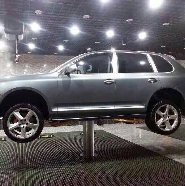รถ SUV สีเทาบนลิฟท์เสาเดียวในร้านคาร์แคร์ไฟส่องสว่าง