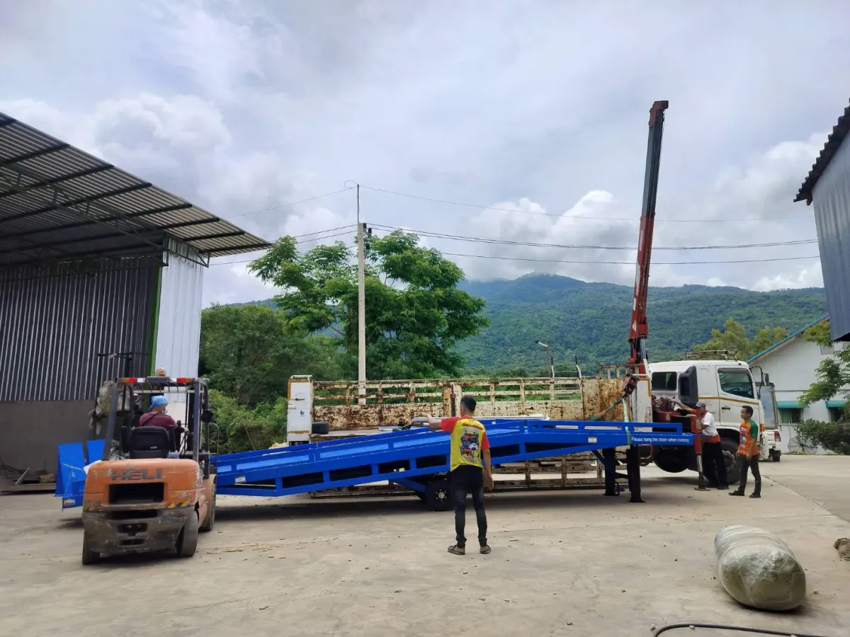 ทีมงานและโฟล์คลิฟท์จัดวางสะพานโหลดสินค้าหลังยกลงจากรถ